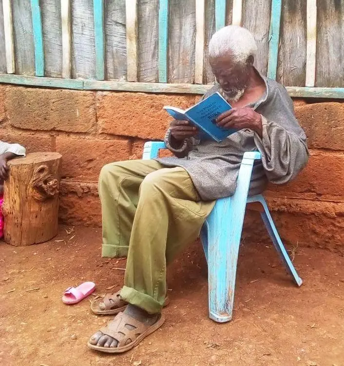 An elderly man in Chuka reading the Bible
